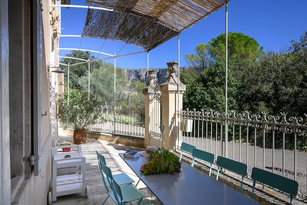 An outdoor patio with a table, chairs, and a pergola.