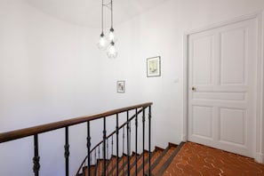 Un escalier avec une rampe en bois et une porte blanche en haut.