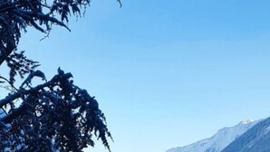 Paisaje montañoso cubierto de nieve con un edificio y un autobús.