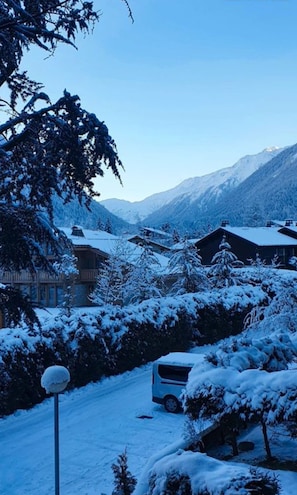 Paisaje montañoso cubierto de nieve con un edificio y un autobús.
