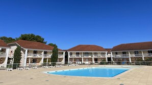A hotel with a swimming pool, multiple balconies, and a clear blue sky. - 226 - Comfortable apartment in a residence with swimming pool in Verdon sur Mer (LE VERDON SUR MER)