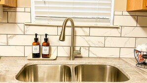 A kitchen with a double sink, wooden cabinets, and a window with blinds. - LOCATION!!  Only 1 mile to downtown Helen. 2 Bedroom, 2 Bath. Gated Community. (Helen)