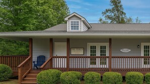 A house with a porch, a blue chair, and a welcome sign. - LOCATION!!  Only 1 mile to downtown Helen. 2 Bedroom, 2 Bath. Gated Community. (Helen)
