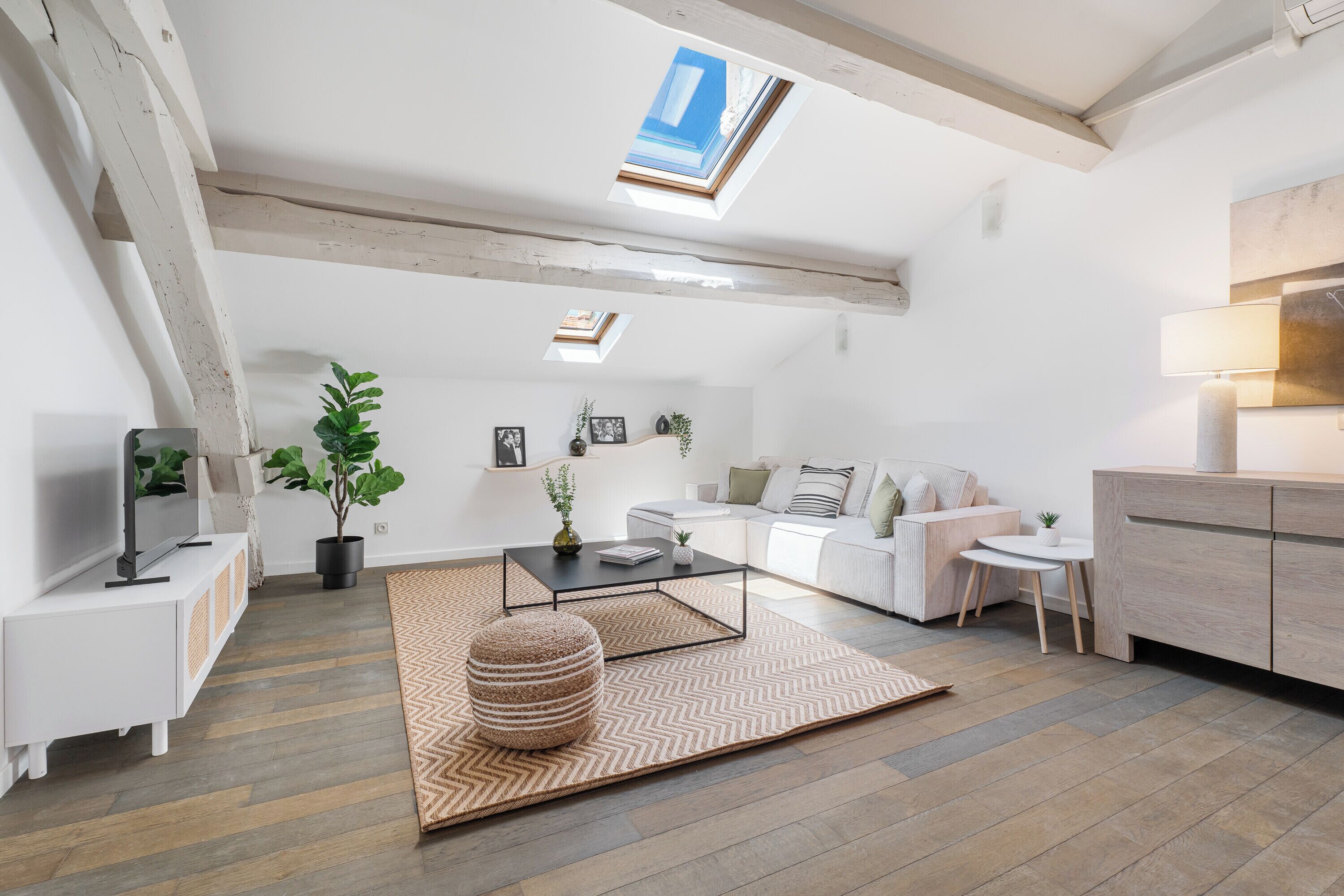 Un salon moderne avec un canapé, une table basse et une lucarne.