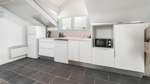 A modern kitchen with white cabinetry, a dishwasher, a microwave, and a built-in oven.