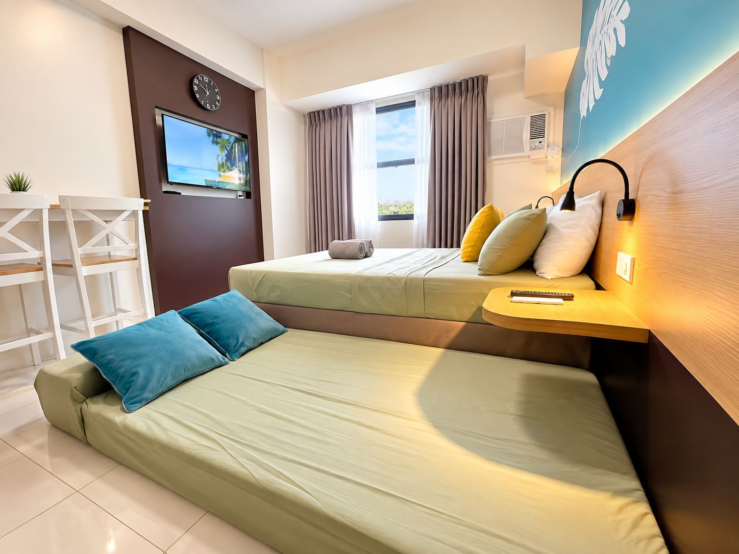 Una habitación de hotel moderna con cama, escritorio, televisor y ventana con cortinas.