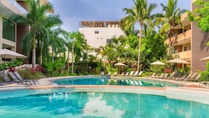 Ein Poolbereich mit Liegestühlen und Palmen.