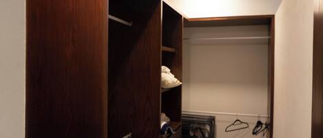 Un dressing avec des portes en bois, des étagères et un espace pour suspendre les vêtements.
