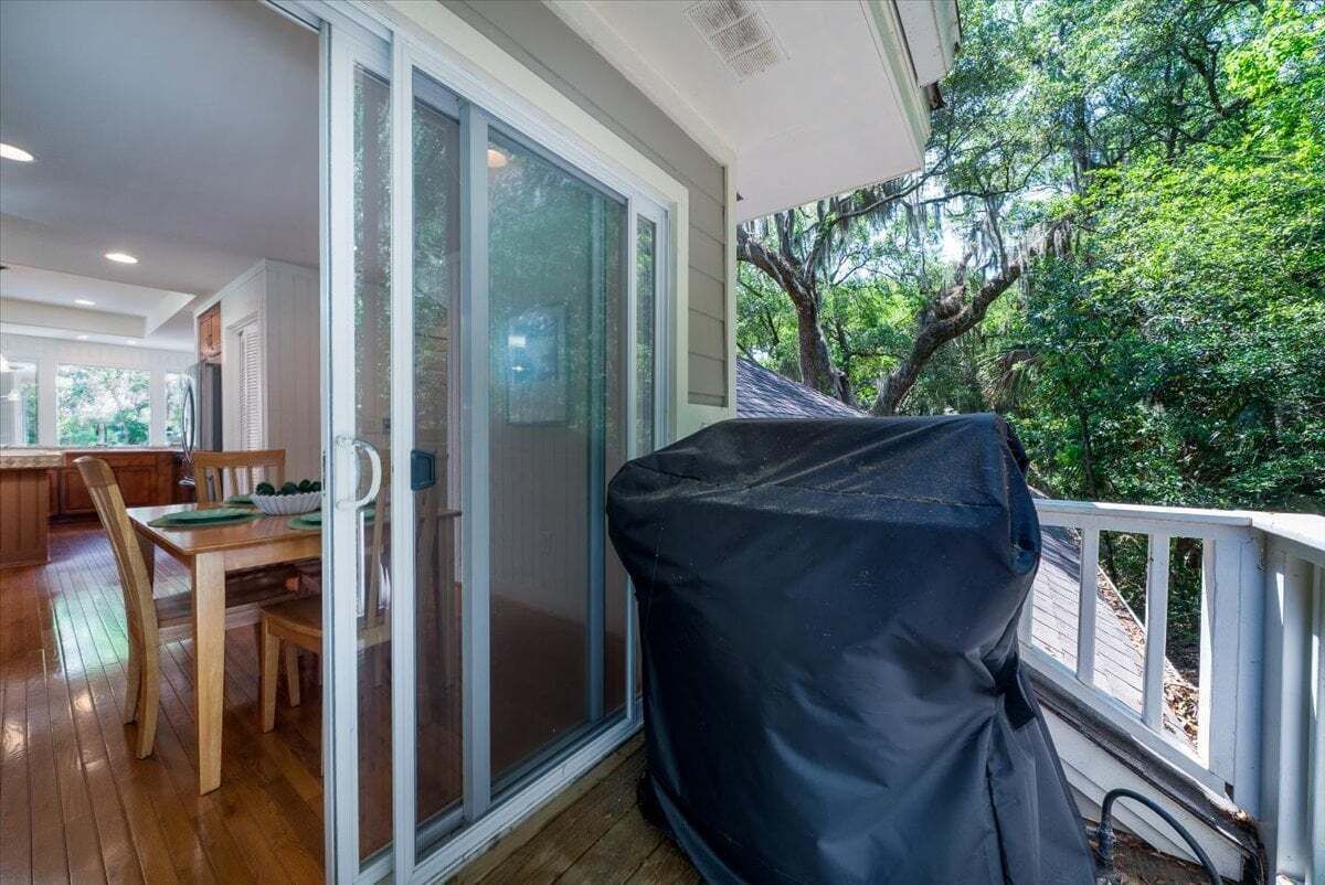 A covered outdoor area with a sliding glass door leading to a dining area.