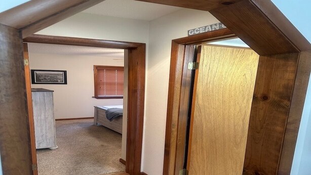 A hallway with wooden flooring and a door labeled "OCEAN". - Charming 2-bedroom condo with WiFi, AC in fantastic North Ocean City (Ocean City)