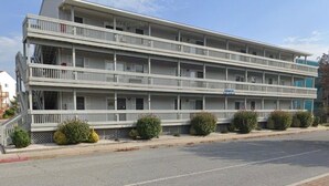 A multi-story motel with balconies, a covered front porch, and a parking lot. - Charming 2-bedroom condo with WiFi, AC in fantastic North Ocean City (Ocean City)