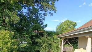 A garden pathway leading to a covered seating area with a pergola. - Les Portes Roses - VARENNE SAINT GERMAIN (VARENNE SAINT GERMAIN)