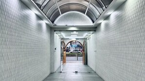 A tunnel-like passageway with white walls and a curved ceiling. - Hotel Tiwintza Internacional (Quito)