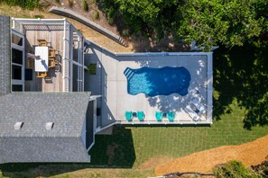 Une piscine sur le toit, avec une terrasse en bois et du mobilier d’extérieur.