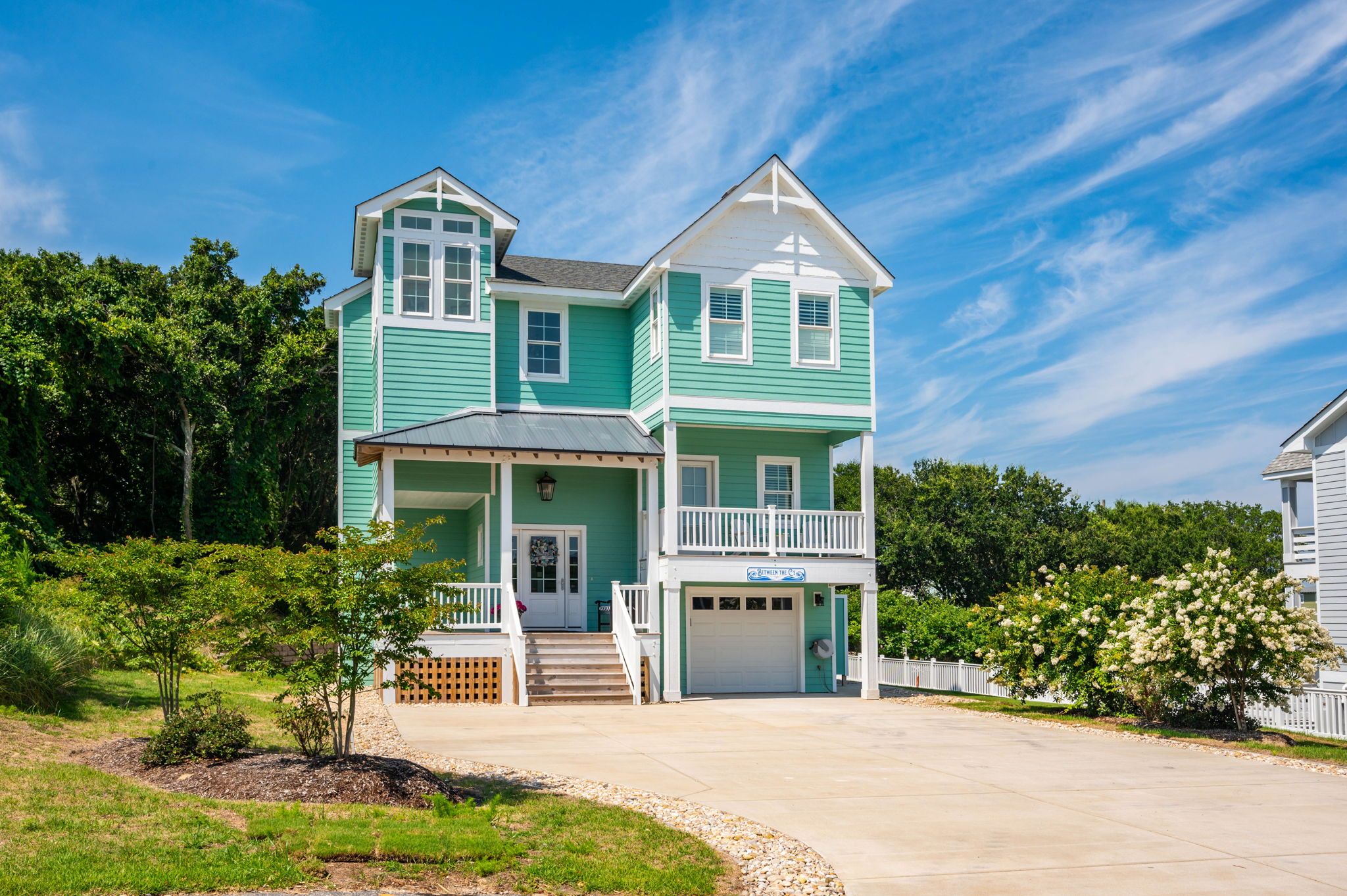 A two-story house with a front porch, a garage, and a well-maintained lawn.