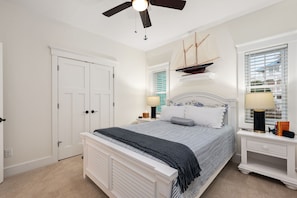 A bedroom with a bed, nightstands, a ceiling fan, a ship model, and a window with blinds. - Between the Cs: Soundside, Private Pool, Elevator (Kitty Hawk)