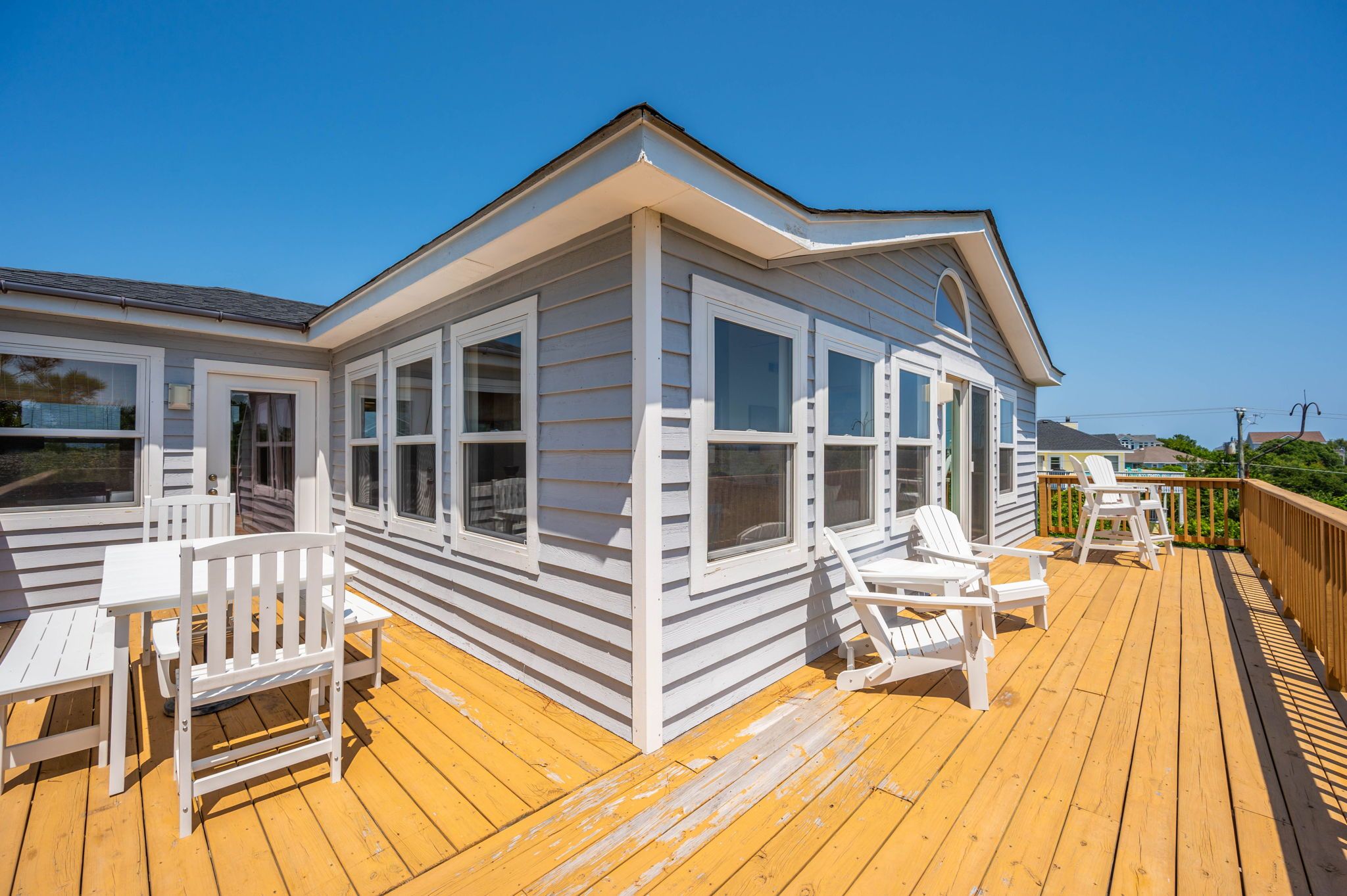 A white wooden building with large windows and a deck.