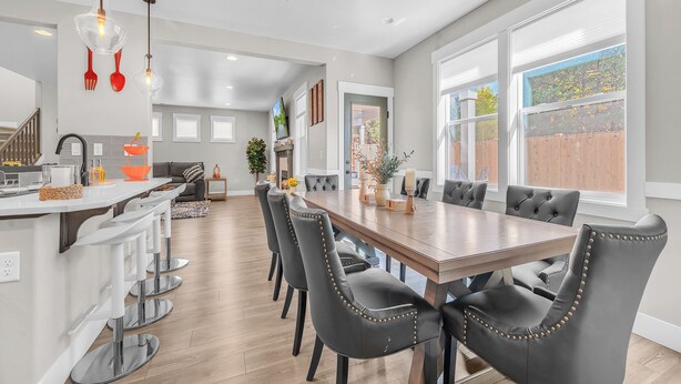 A spacious kitchen with a dining area, featuring a large wooden table and modern chairs.
