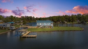 A lakeside house with a dock, surrounded by trees and a calm lake. - Carolina Breeze - Your Perfect Getaway! (Merritt)