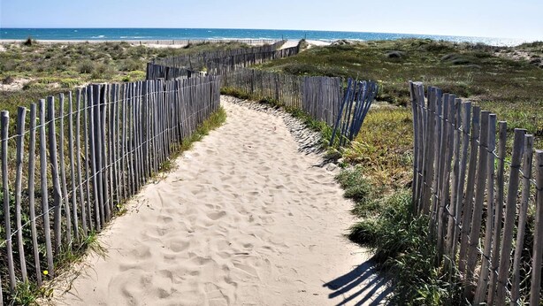 A sandy path flanked by wooden fences leading to a beach. - 2-Bedroom holidays Cottage with 2 Terrace, Air Conditioning  et  Parking (CANET PLAGE)