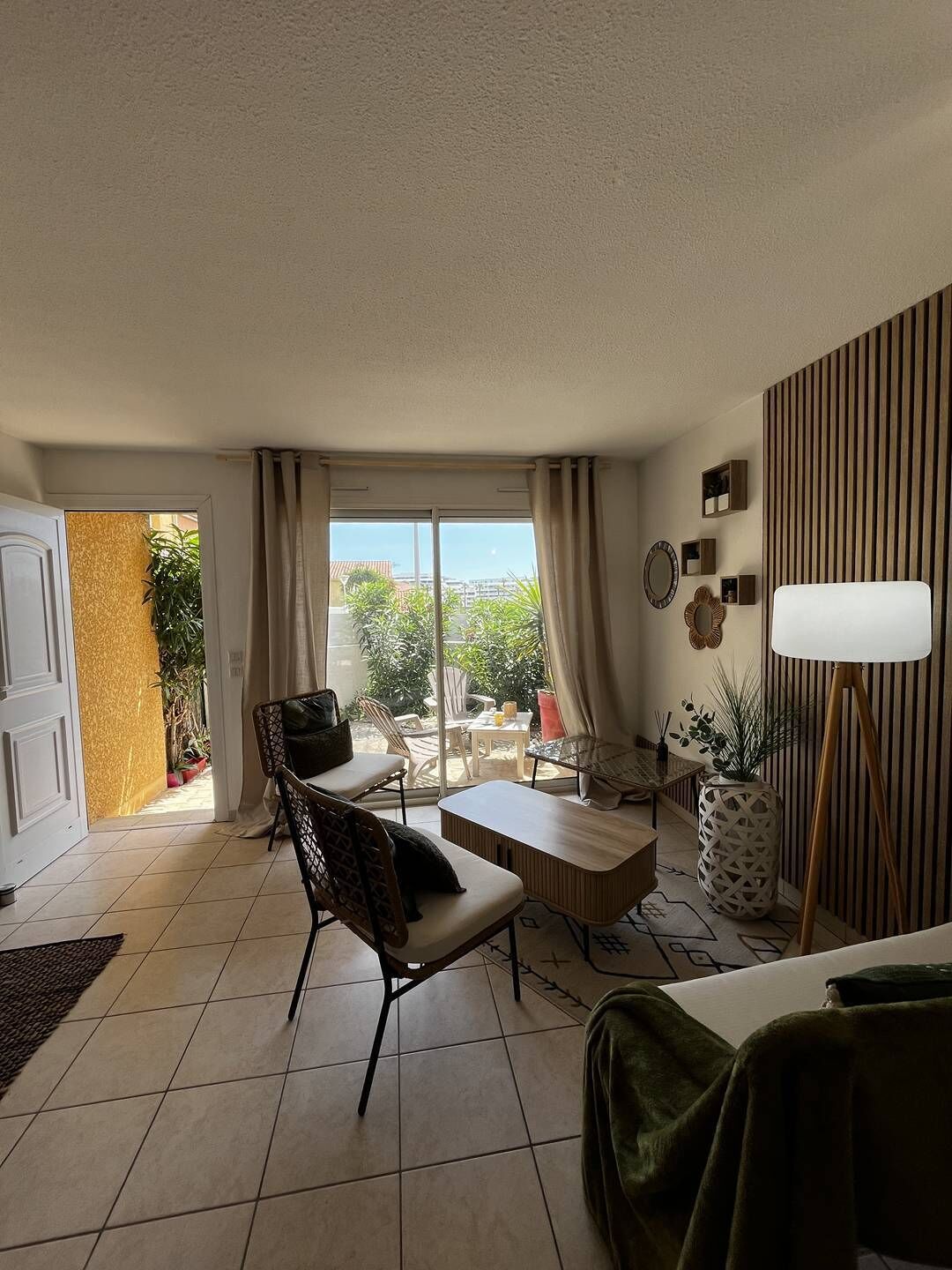 Ein modernes Wohnzimmer mit Blick ins Freie, einem Essbereich und einem großen Fenster mit Vorhängen.
