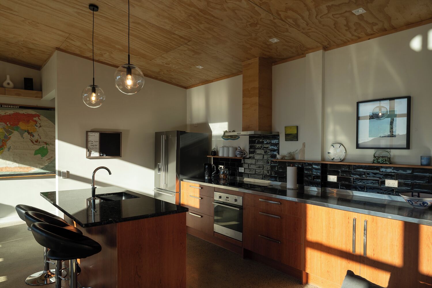 Una cucina moderna con isola centrale, elettrodomestici in acciaio inossidabile e soffitto in legno.