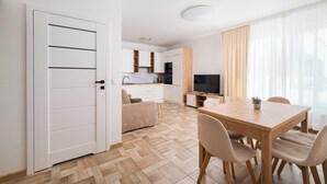 A modern apartment with a dining area, kitchen, and living space. - Włochy Równoległa Cosy Apartment (Warszawa)