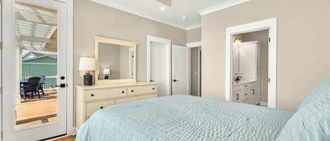 Un dormitorio con cama, cómoda y un espejo grande.