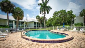A circular pool with a tiled edge, surrounded by lounge chairs and a fence. - Sunsets and Palm Trees overlooking the St. Lucie River (Stuart)