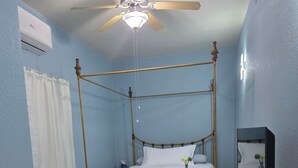 A four-poster bed with a wooden frame, a bench at the foot of the bed, a ceiling fan, and a television on a stand. - Charming 1-bedroom apartment with WiFi and AC in delightful Port Charlotte (Port Charlotte)