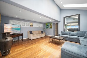 Relax in this stylish living room with a large flat-screen TV, comfortable sofas, and wall-mounted artworks.