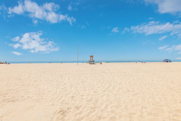 Enjoy sunbathing and swimming on this expansive public beach with a lifeguard tower for added safety.