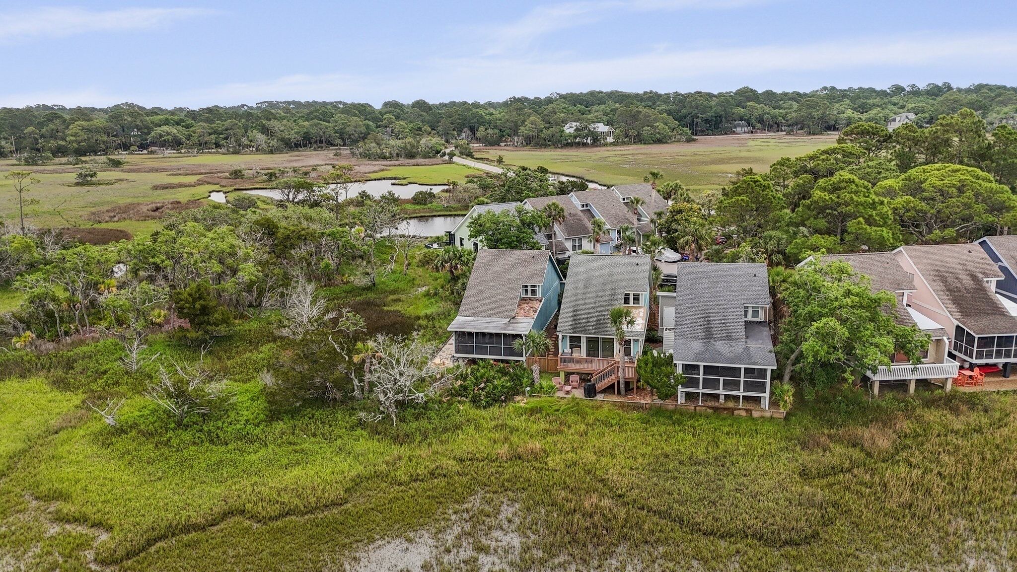 A residential area with houses surrounded by lush greenery and a river.