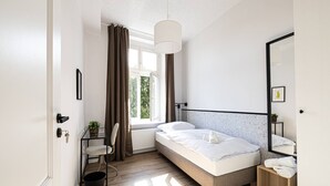 A modern bedroom with a bed, a chair, a small table, and a window with curtains. - Verde 3 Pok j 1-os Wifi Dolny Gda sk (Gdansk)