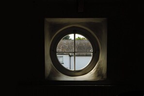 A circular window with a view of a building and a clear sky.