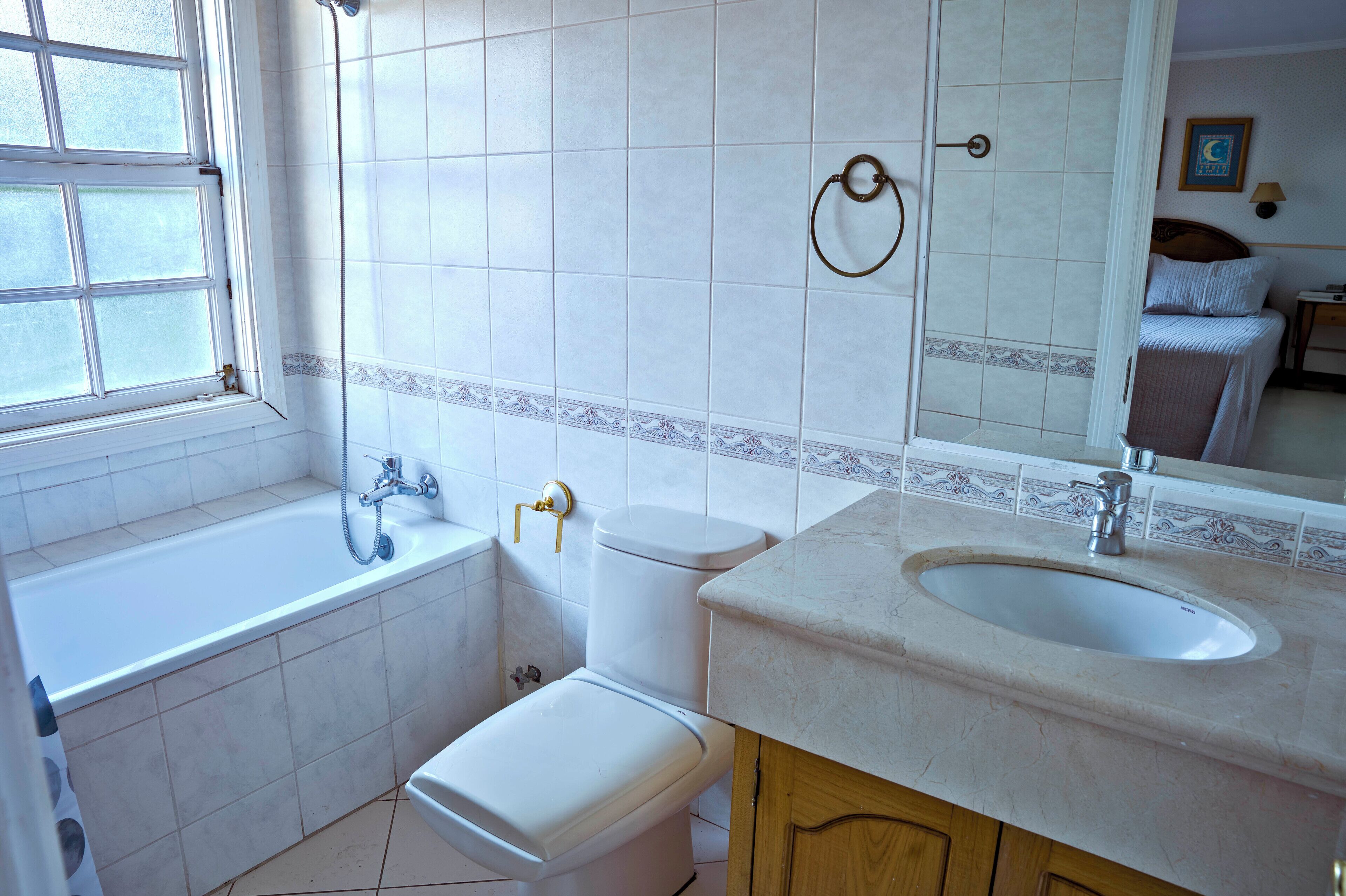 A bathroom with a bathtub, toilet, sink, and a shower.