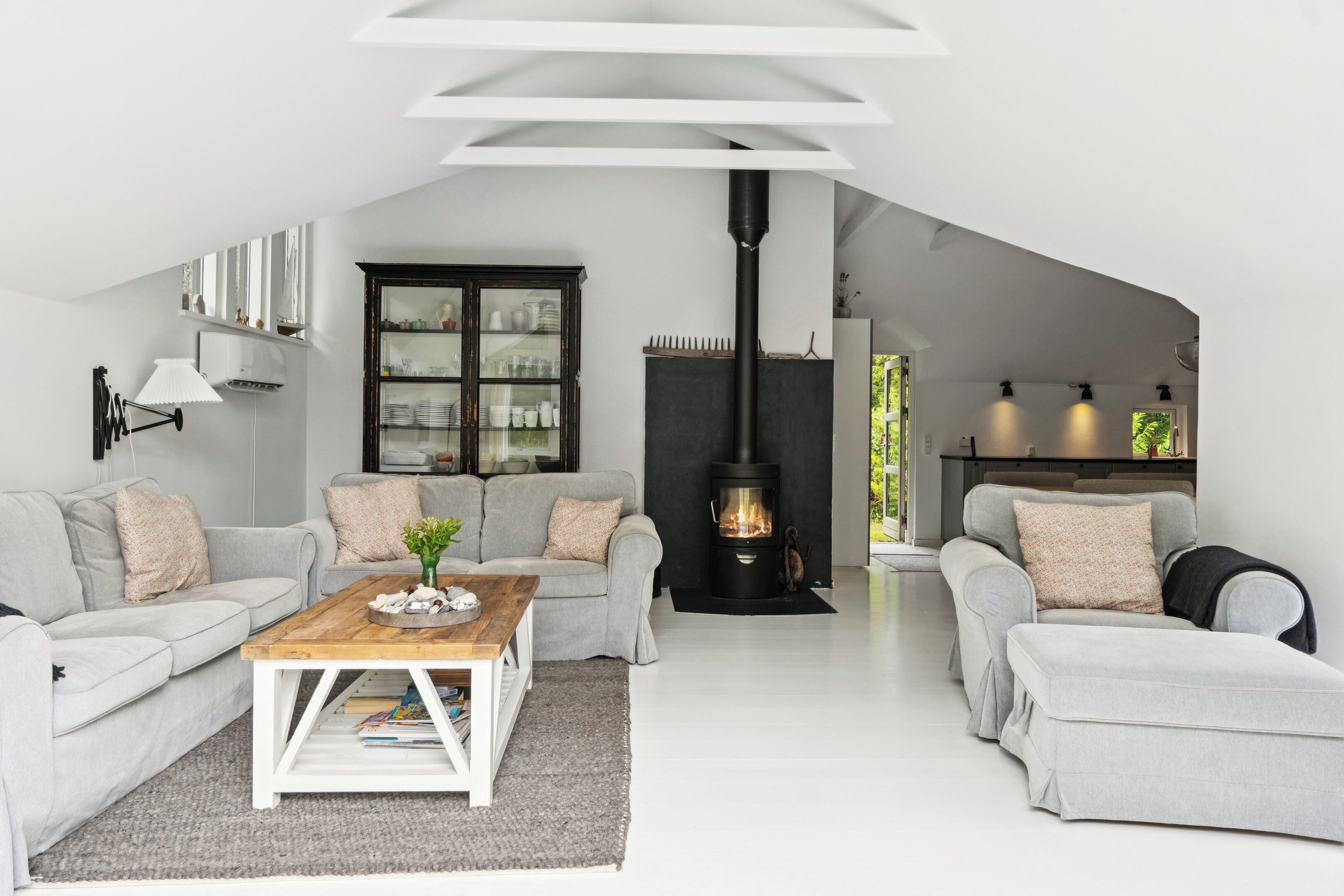 Un salon moderne de style industriel, avec une cheminée, deux canapés, une table basse et un meuble.