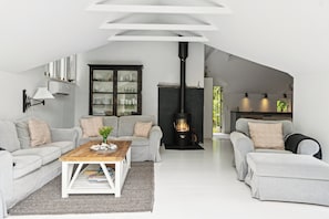Ein stilvolles Loft-Wohnzimmer mit Kamin, zwei Sofas, einem Couchtisch und einem Schrank.