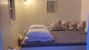 A bedroom with a bed, bedside lamps, a window, and a framed picture on the wall. - A cozy older summerhouse on a small island (Orø)