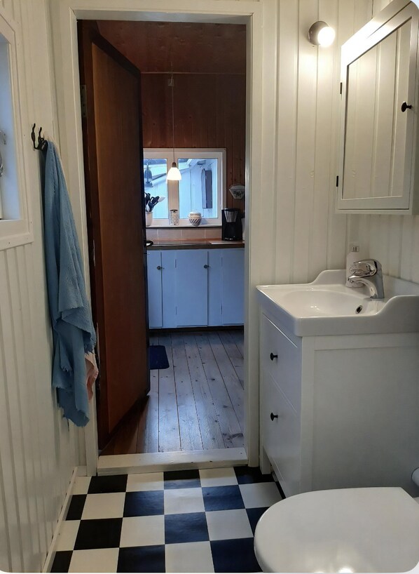 Ein Badezimmer mit Waschbecken, Toilette und Fußboden in Schachbrettmuster.