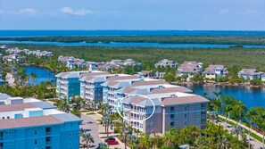 Un resort costero con edificios de varios pisos, un puerto deportivo y vistas al océano.