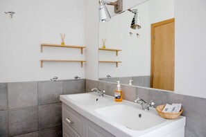 A bathroom with two sinks, a mirror, and a wooden door. - CASA DA BEIRÃ T2, country house (Marvão)