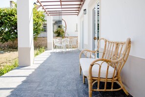 A covered outdoor seating area with wicker furniture and a tiled floor. - CASA DA BEIRÃ T2, country house (Marvão)