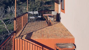 A covered outdoor seating area with a brick floor, metal railing, and a pergola. - MURTA PEQUENA T2 with private pool (Marvão)
