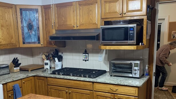 A kitchen with wooden cabinets, a microwave, a toaster, and a stove. - Charming 4-bedroom home with WiFi, AC ,  deck and firepit in delightful Montross (Montross)