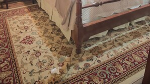 A traditional bedroom with a four-poster bed, a nightstand with a lamp, a dresser, and a floral-patterned rug. - Charming 4-bedroom home with WiFi, AC ,  deck and firepit in delightful Montross (Montross)