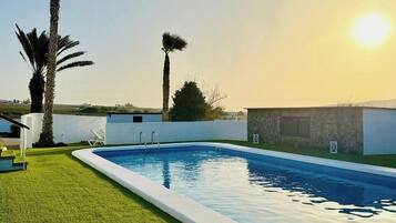 Piscina com vista clara do céu e paisagem distante.