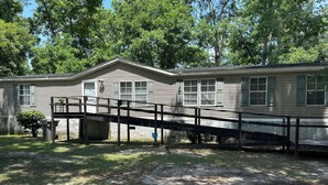 A single-story mobile home with a covered porch and a small attached garage.