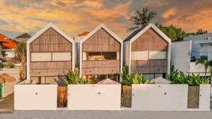 A modern building with three distinct sections, each with a sloped roof and a wooden facade. - Charming 1-bedroom villa with swimming pool (Tibubeneng)