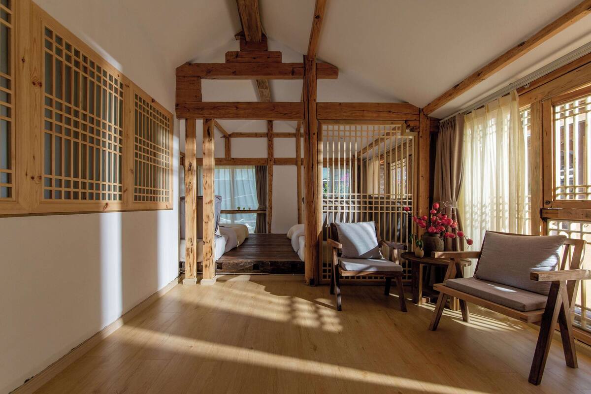 Ein traditioneller japanischer Raum mit Tatami-Boden, Holztüren und einem niedrigen Bett.